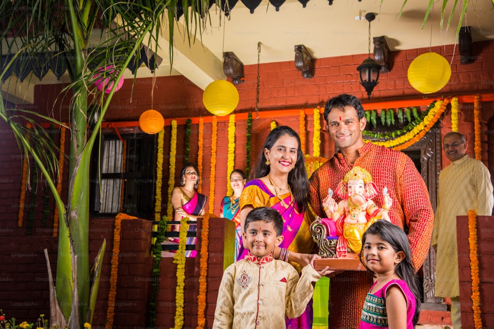 fröhliche indische Familie, die Lord Ganesha-Idol auf dem Ganesh-Fest oder Ganesh Chaturthi auf Palkhi begrüßt, das mit Girlandenblumen geschmückt ist