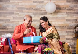 Casal sênior indiano em caixas de presente de abertura de roupas tradicionais, casal asiático e presentes de diwali