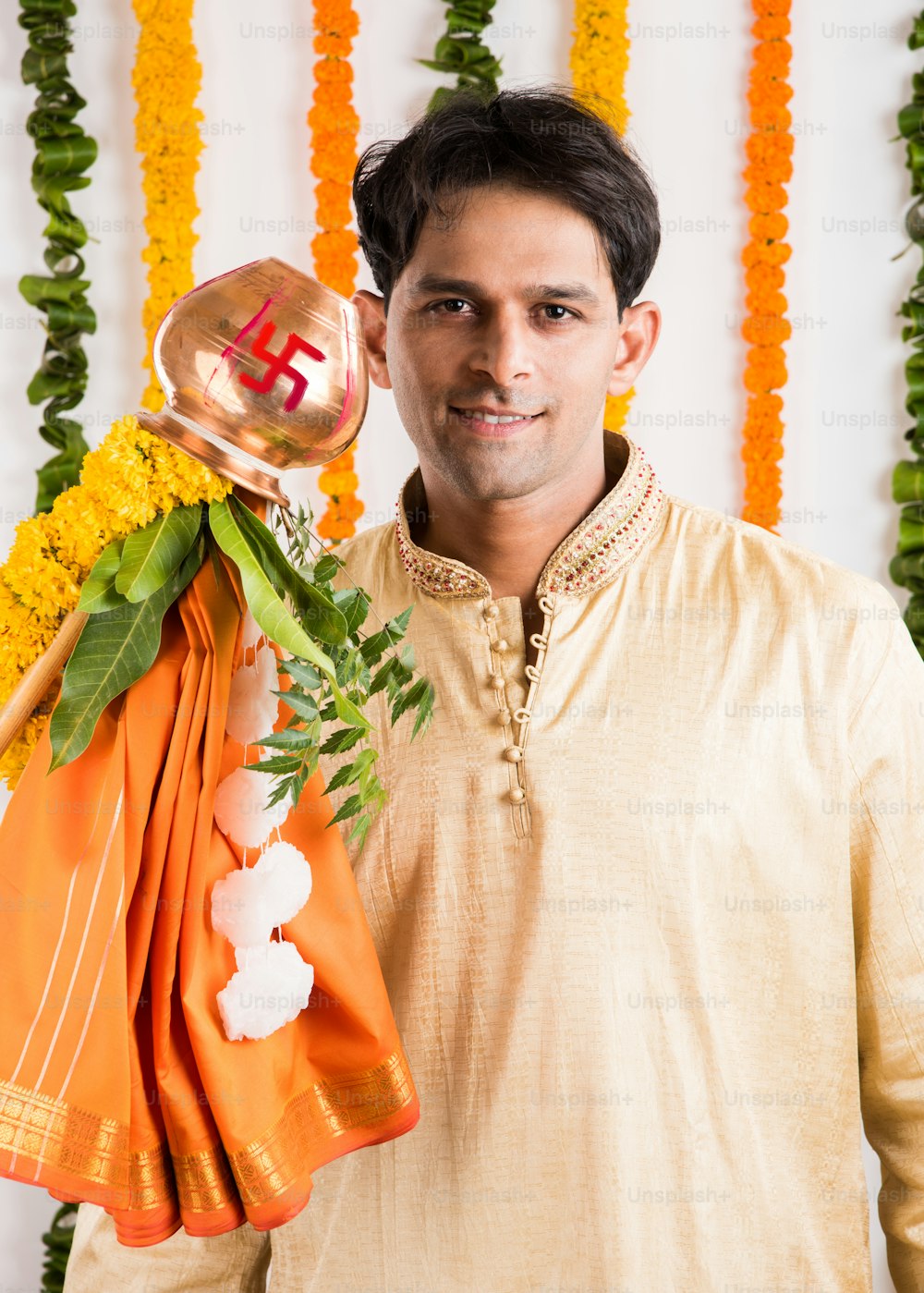 Un bel homme indien à Kurta Payjama debout avec Gudi pour la célébration de Gudi Padwa
