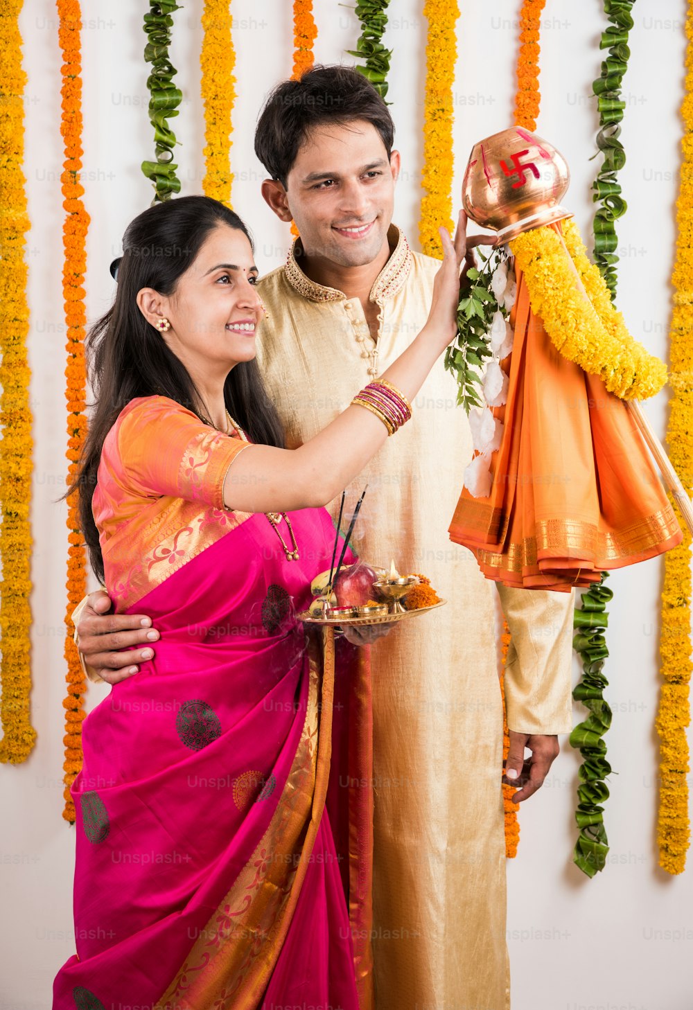 Kluges indisches Paar, das Gudhi Padwa Puja, asiatisches Paar und Puja Thali, indisches junges Paar, das Puja oder Pooja durchführt, hinduistisches Neujahrsfest Gudhi Padwa / Gudi Padwa, indisches Paar, das in traditioneller Kleidung betet