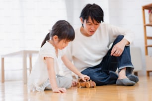 Little girl playing at home with her father