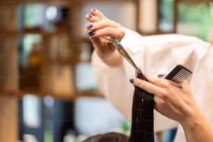 Une fille se fait couper les cheveux dans un salon de beauté.