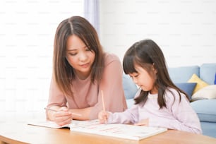 Uma garotinha estudando com sua mãe