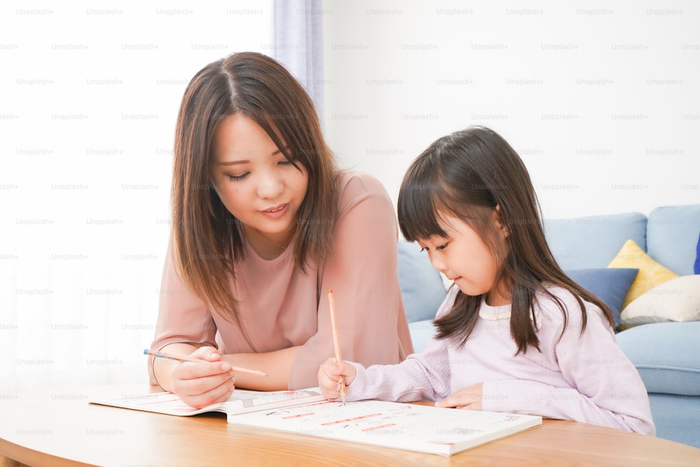 A little girl studying with her mother