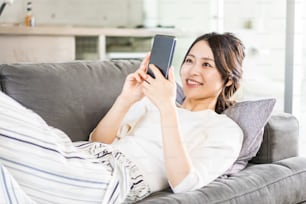 Jeune femme utilisant un smartphone dans sa chambre