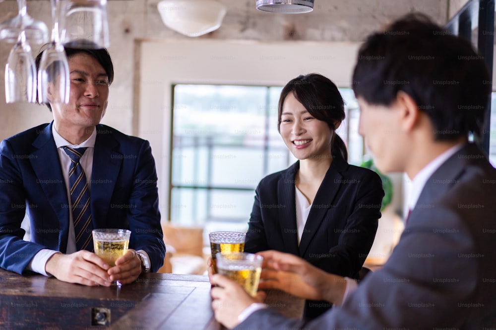 Male and female businesspersons drinking alcohol at bar