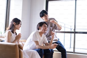 Young men and women playing video games at home