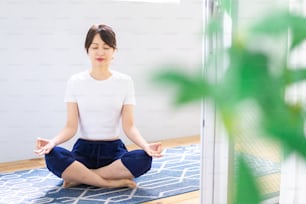 Jeune femme faisant du yoga à la maison