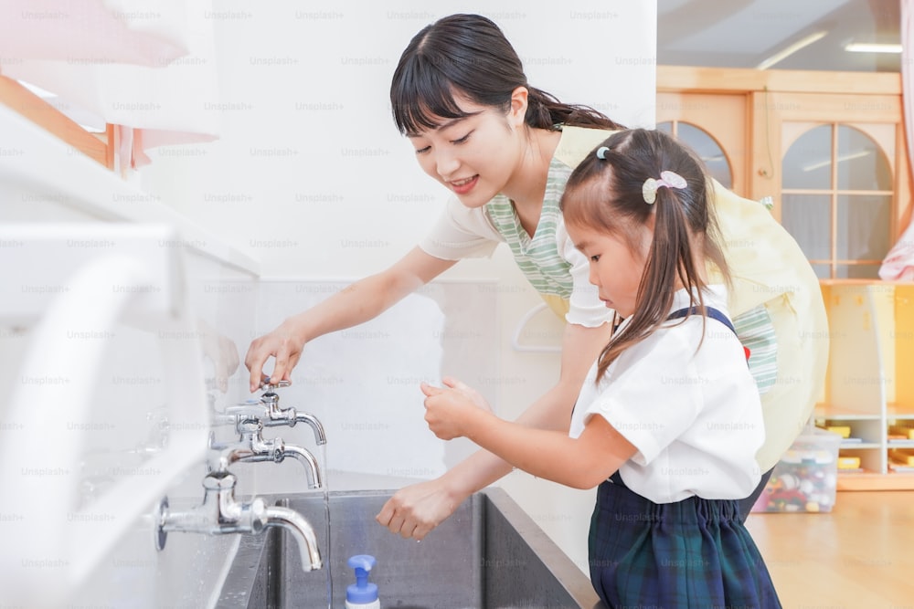 Girl and teacher washing hands