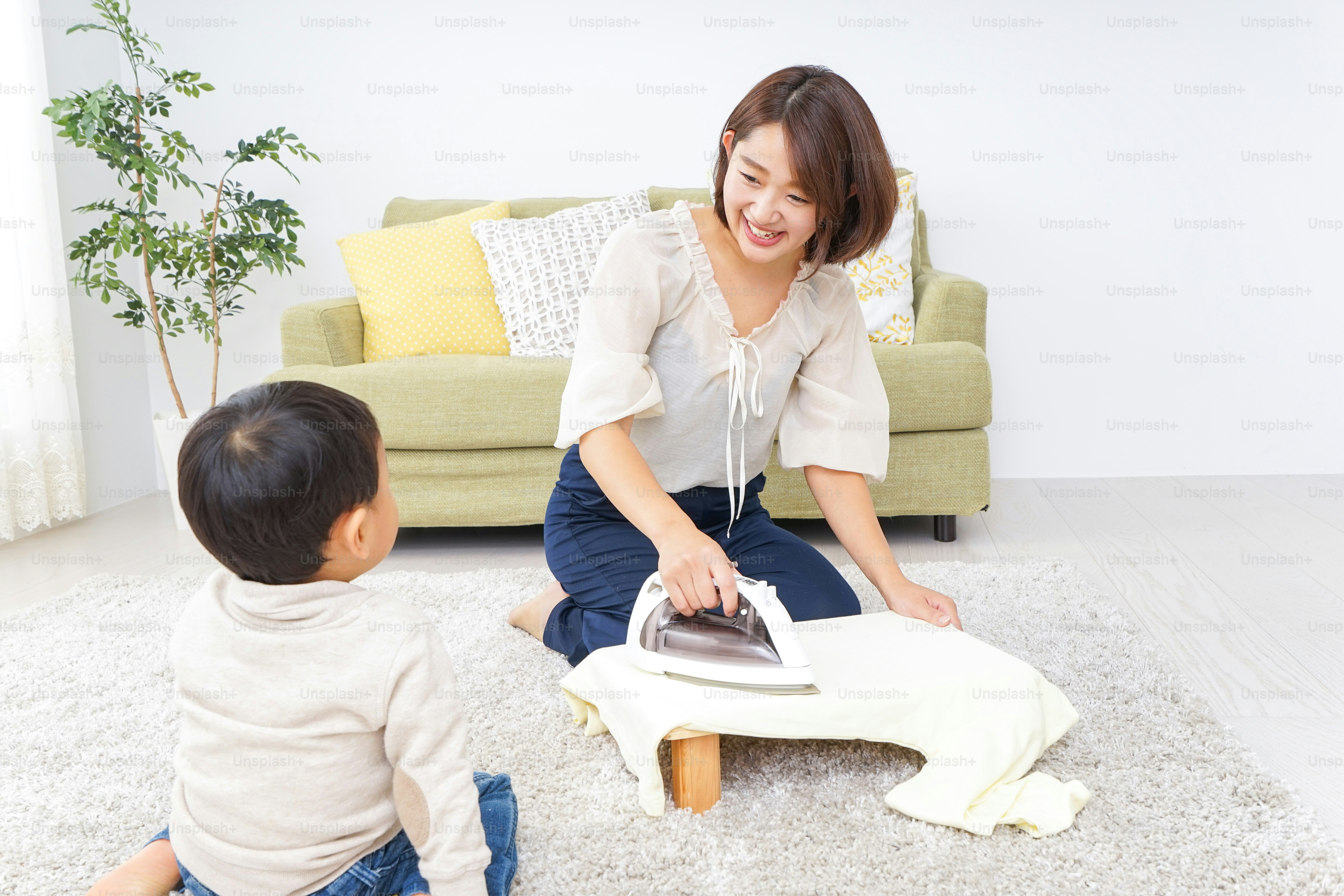 Mother doing household chores and child