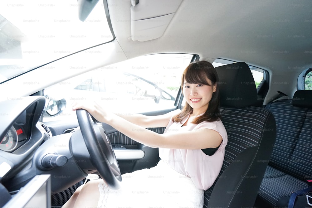 Giovane donna che guida una macchina