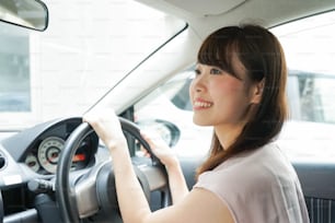 Giovane donna che guida una macchina