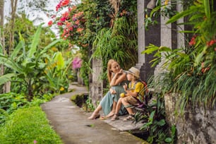 Mutter-Sohn-Touristen in Bali spazieren durch die engen, gemütlichen Gassen von Ubud. Bali ist ein beliebtes Touristenziel. Reisen Sie nach Bali. Konzept des Reisens mit Kindern.