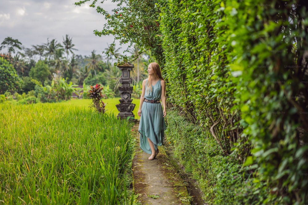 Young woman tourist in Bali walks along the narrow cozy streets of Ubud. Bali is a popular tourist destination. Travel to Bali concept.
