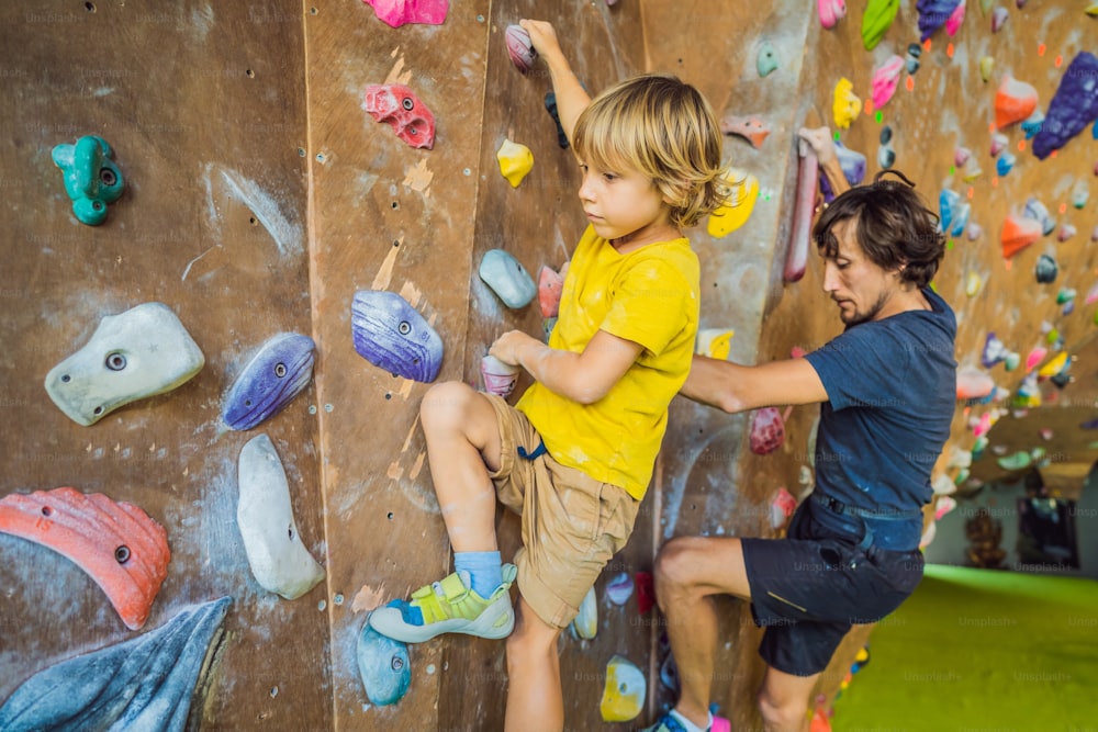 Papá e hijo en el muro de escalada. Deporte familiar, estilo de vida saludable, familia feliz.