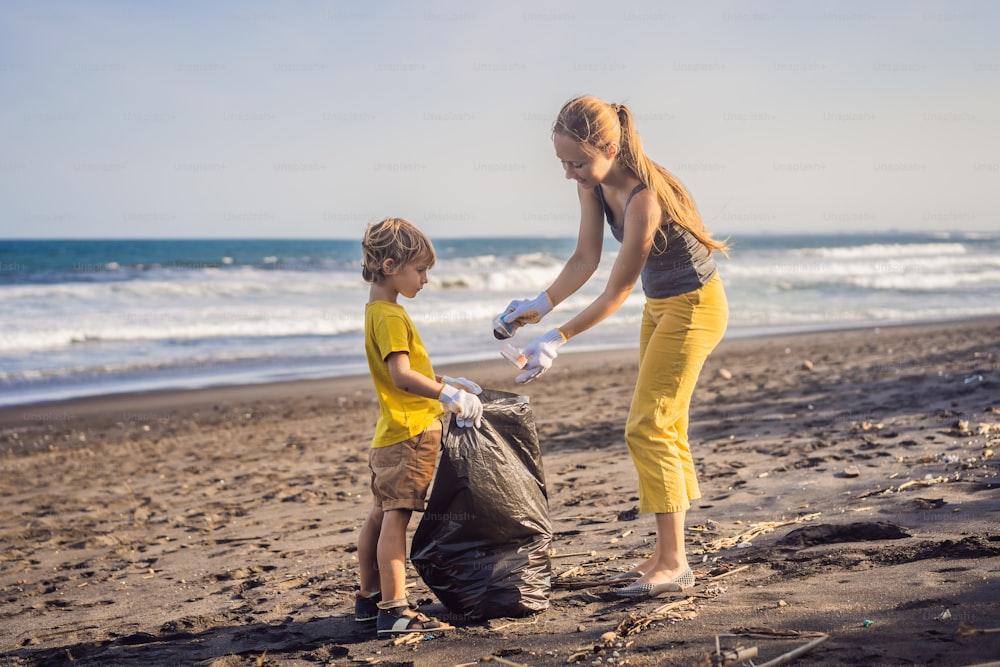 Mãe e filho estão limpando a praia. Educação natural das crianças.