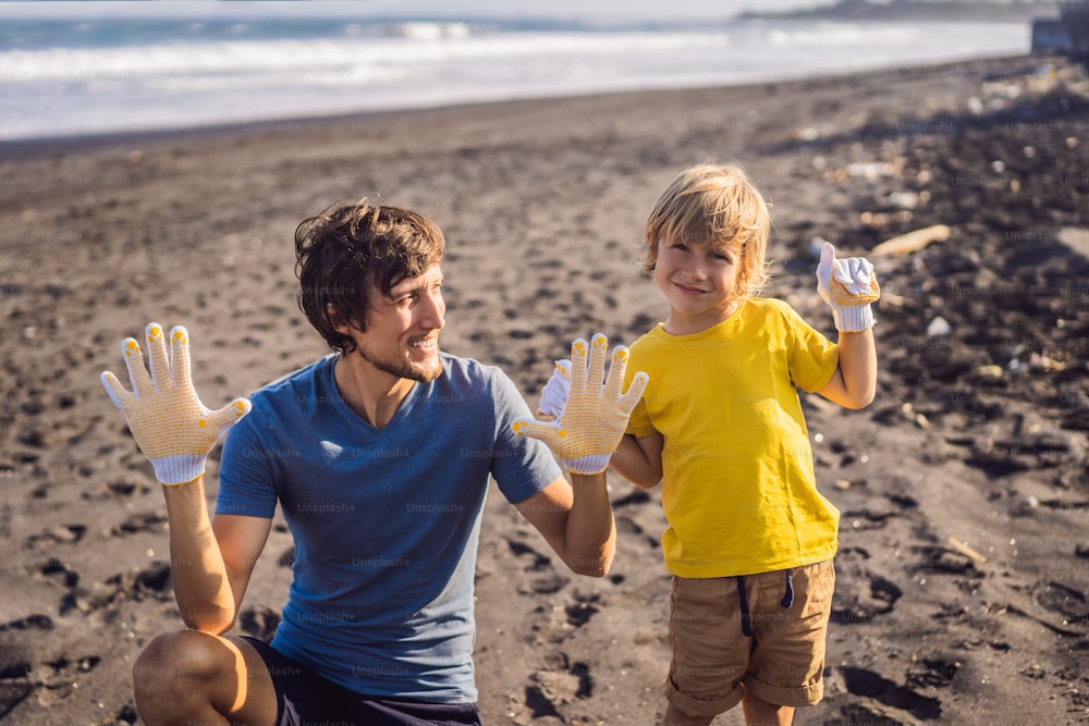 Papa et fils nettoient la plage. Éducation naturelle des enfants.