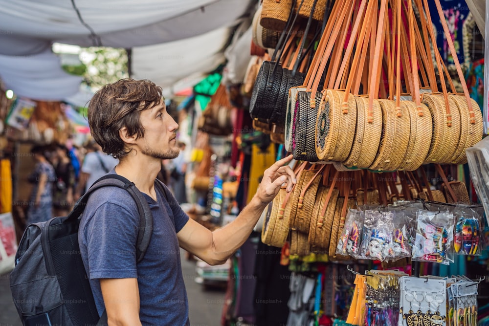 バリ島ウブドの市場で男。インドネシアの有名なウブド市場でバリのお土産や手工芸品を販売する典型的な土産物店。バリの市場。地元住民の木や工芸品のお土産。