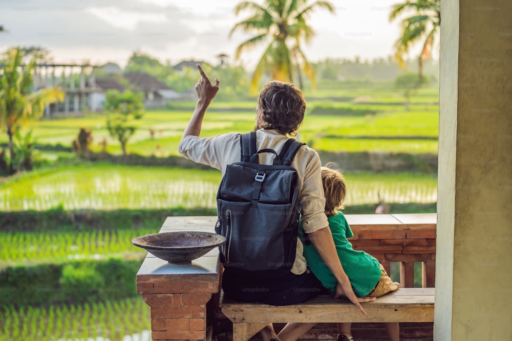 Papá e hijo viajeros en hermosas terrazas de arroz con el fondo de famosos volcanes en Bali, Indonesia Concepto de viajar con niños.