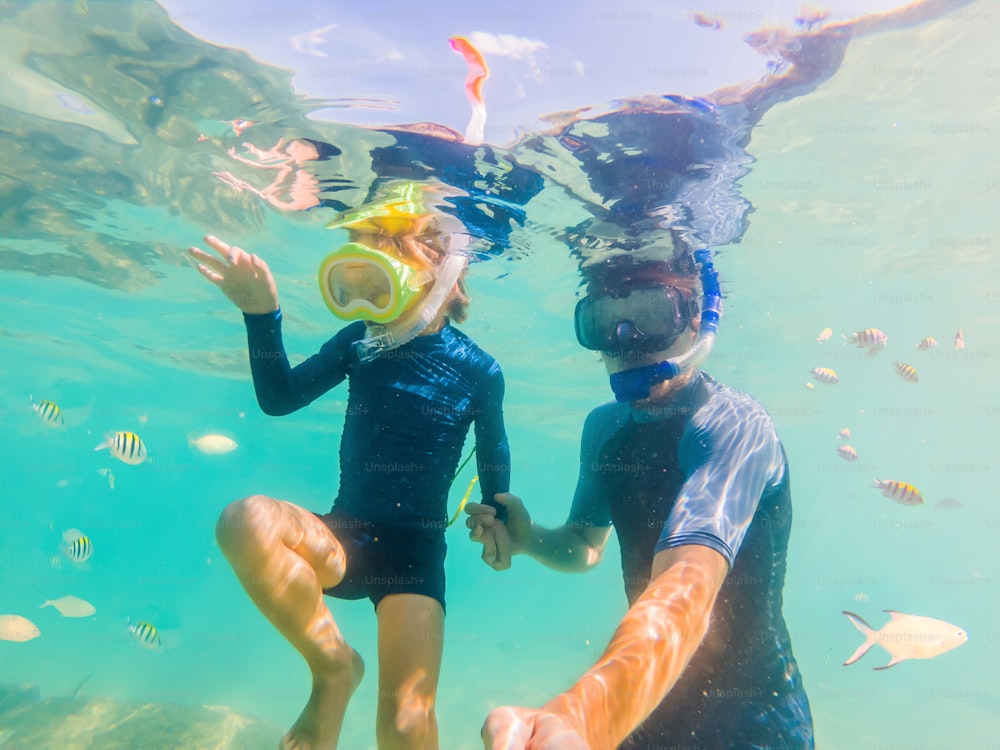 Underwater portrait of father and son snorkeling together.
