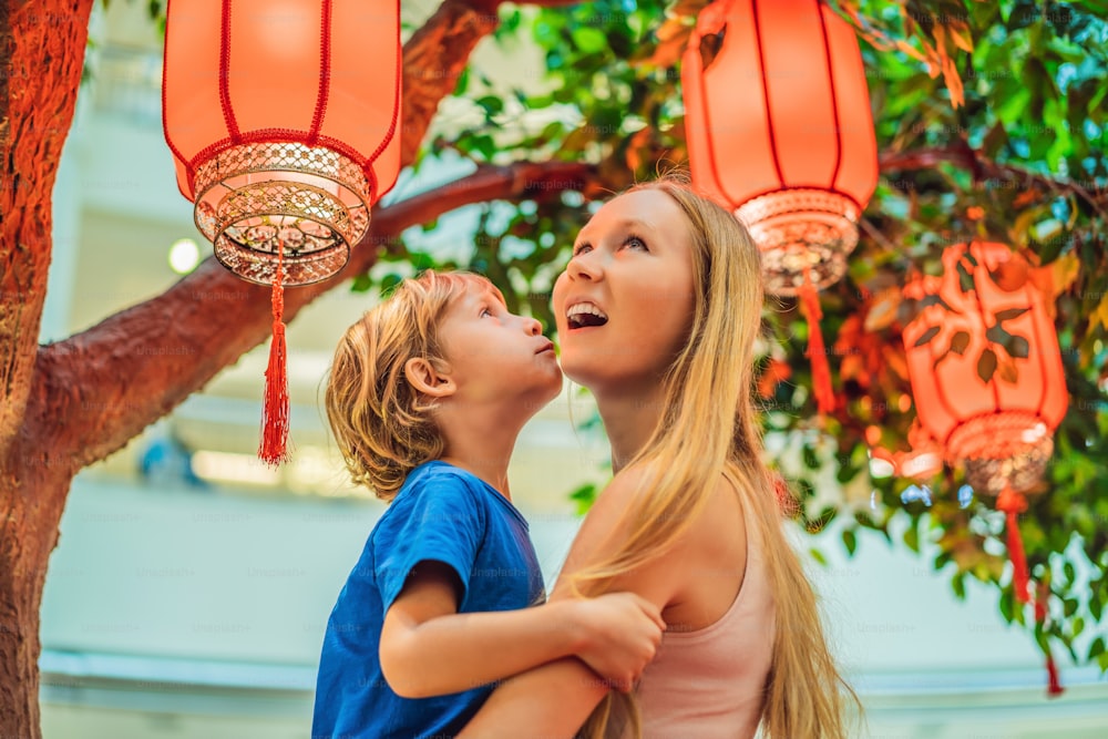 Mutter und Sohn feiern das chinesische Neujahrsfest und schauen sich chinesische rote Laternen an.
