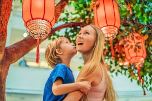 Mutter und Sohn feiern das chinesische Neujahrsfest und schauen sich chinesische rote Laternen an.