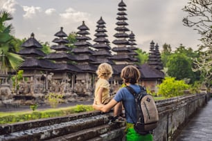 Turistas de padre e hijo en el templo hindú balinés tradicional Taman Ayun en Mengwi. Bali, Indonesia. Concepto de viajar con niños.