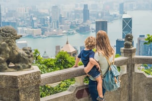 Mom and son travelers at the peak of Victoria against the backdrop of Hong Kong. Traveling with children concept.