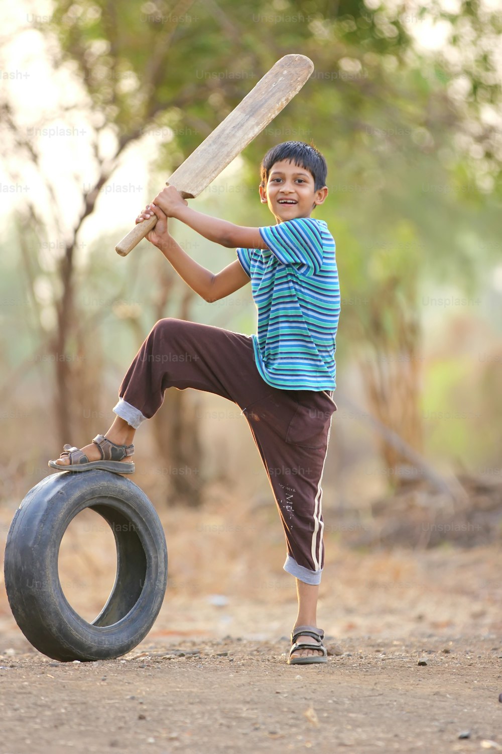Niño indio rural jugando al cricket