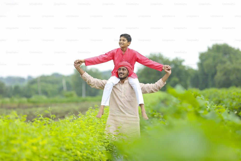 Contadino indiano con il suo figlio al campo agricolo