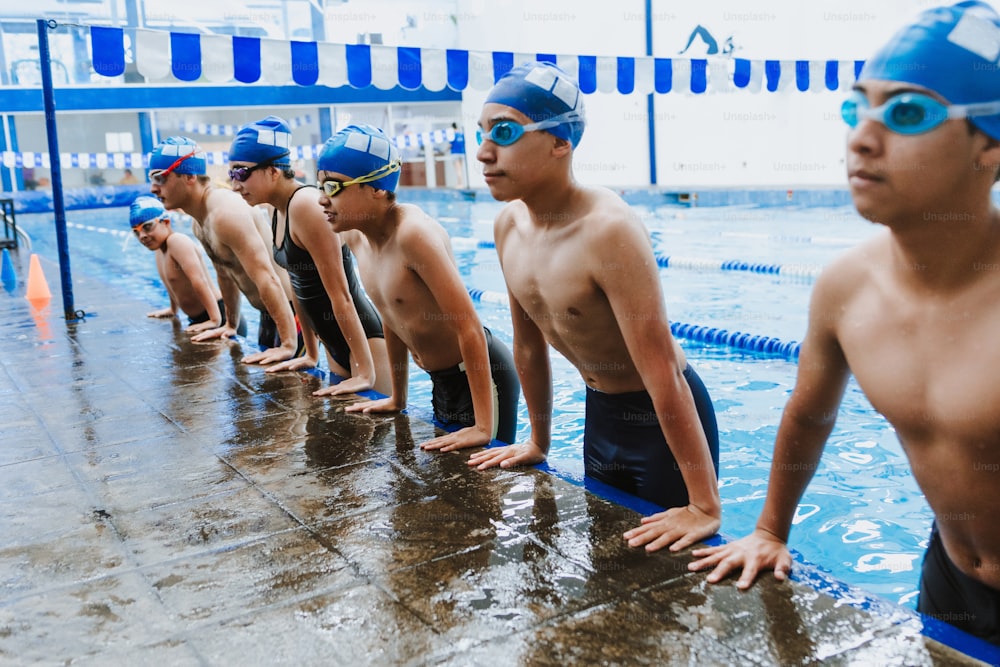 latin young man swimmer wearing cap and goggles in a swimming training at the Pool in Mexico Latin America