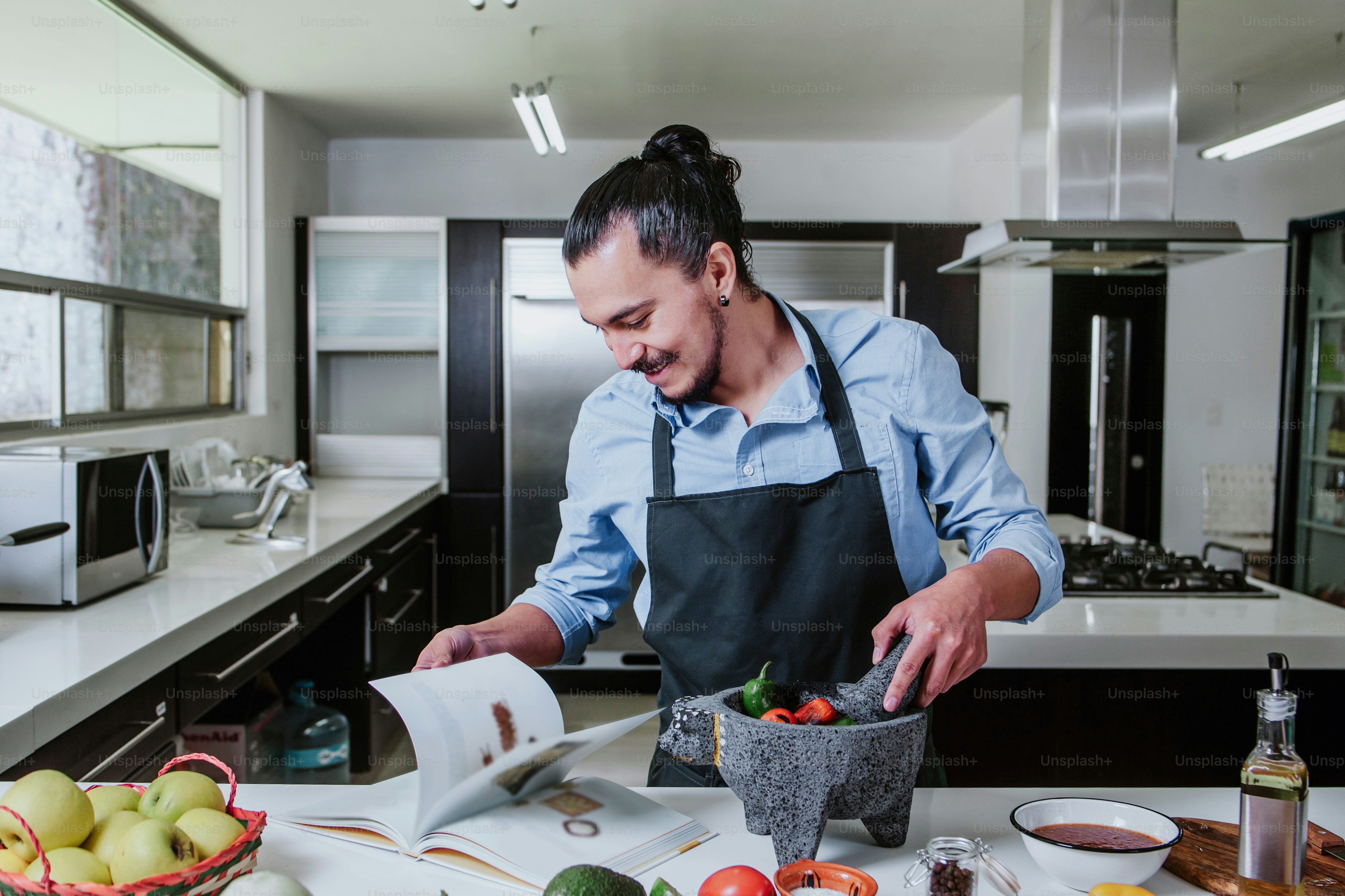 latin man cooking at home preparing salad or mexican sauce in kitchen at home in Mexico city