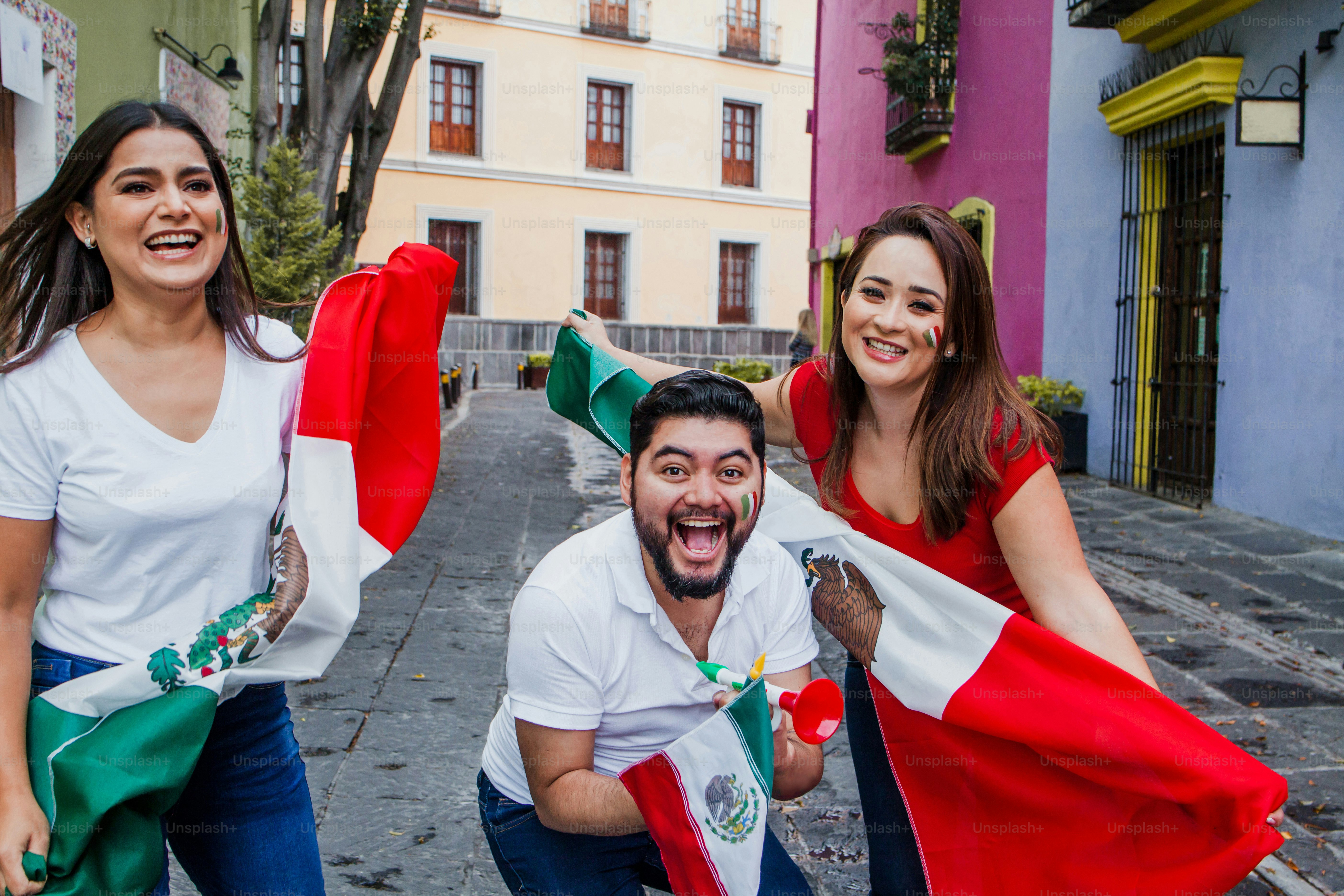 Young mexican soccer fans holding flags in Mexico