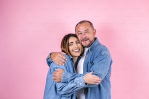 メキシコのピンクの背景にカジュアルな服を着たラテン系の父と娘、コピー用スペース ラテンアメリカ