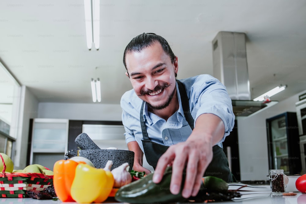 hombre latino cocinando en casa preparando ensalada o salsa mexicana en la cocina en casa en la ciudad de México