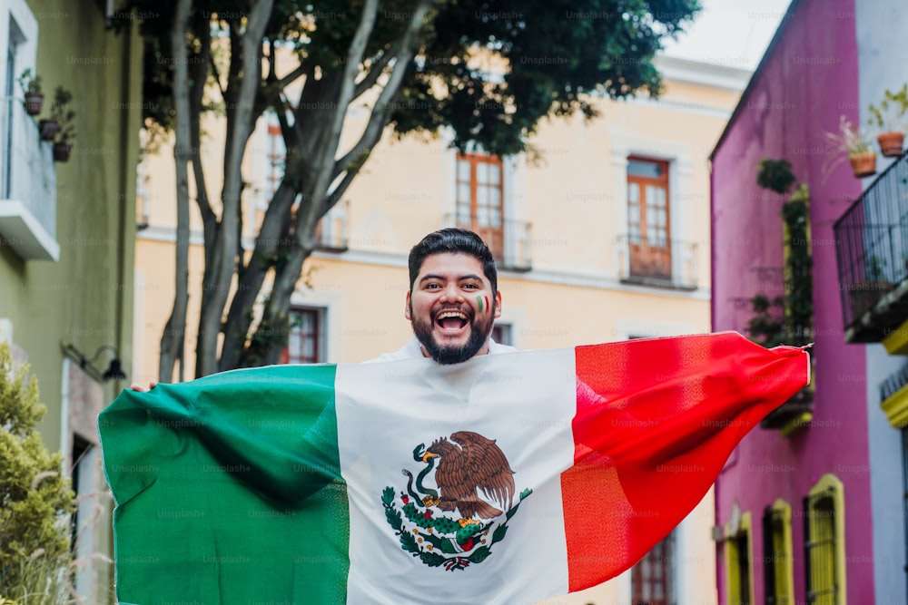 Mexikanischer Mann, der eine Flagge von Mexiko hält