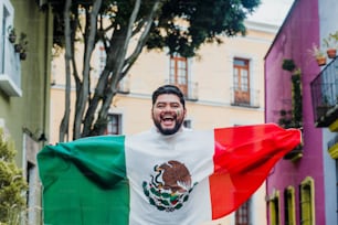 Mexikanischer Mann, der eine Flagge von Mexiko hält