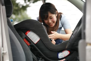 Mother putting her child in a child seat