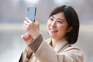 Frau fotografiert mit einem Smartphone