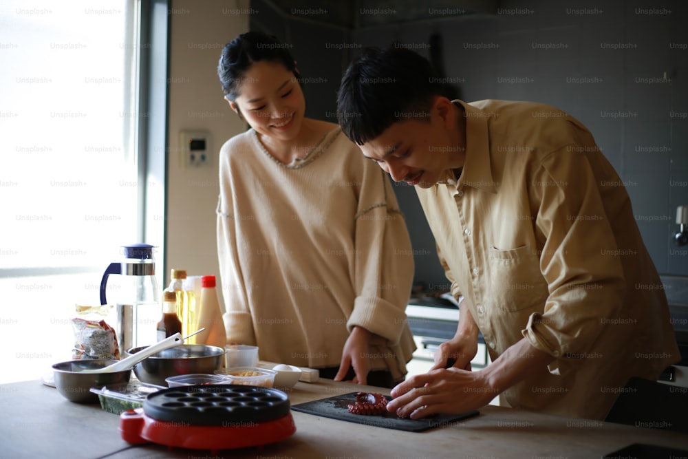 Um casal fazendo takoyaki em casa