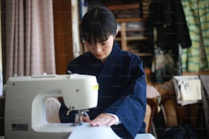 Mulher que usa uma máquina de costura