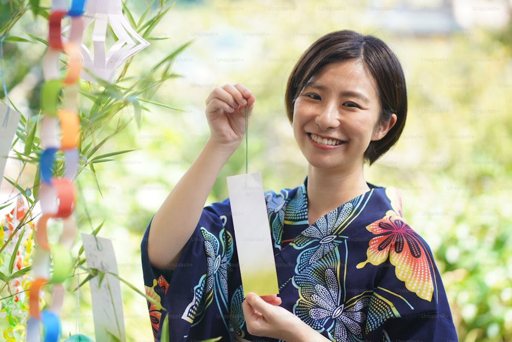 A woman who attaches a strip of paper to Tanabata bamboo