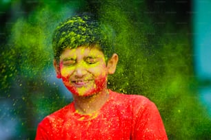 홀리 축하 행사 - 홀리를 연주하고 얼굴 표정을 보여주는 인도 어린 소년.