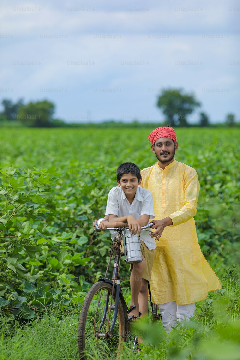 Contadino indiano o lavoro con il suo bambino al campo di cotone
