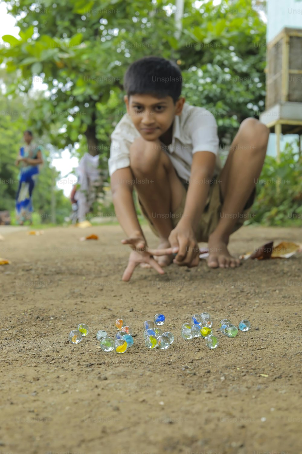 Criança indiana brincando com bolinhas de vidro que é um antigo jogo de aldeia indiana. Mármores de vidro também são chamados de Kancha na língua hindi.