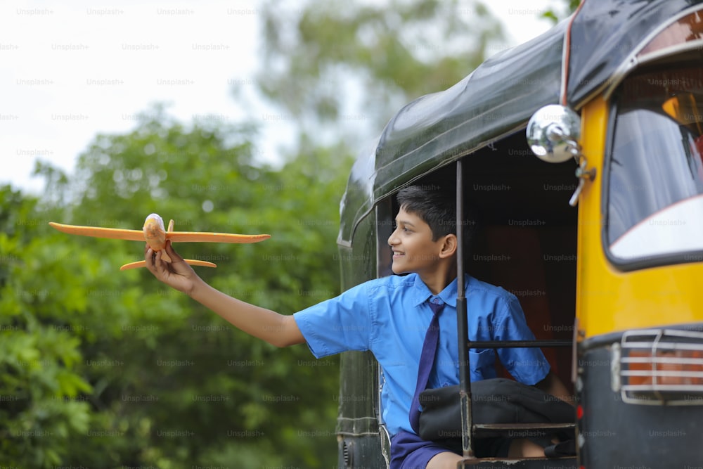 ¡Sueños de vuelo! Niño indio jugando con un avión de juguete