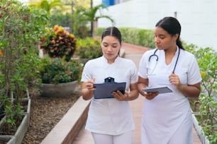 Two nurses walking around checking patient data
