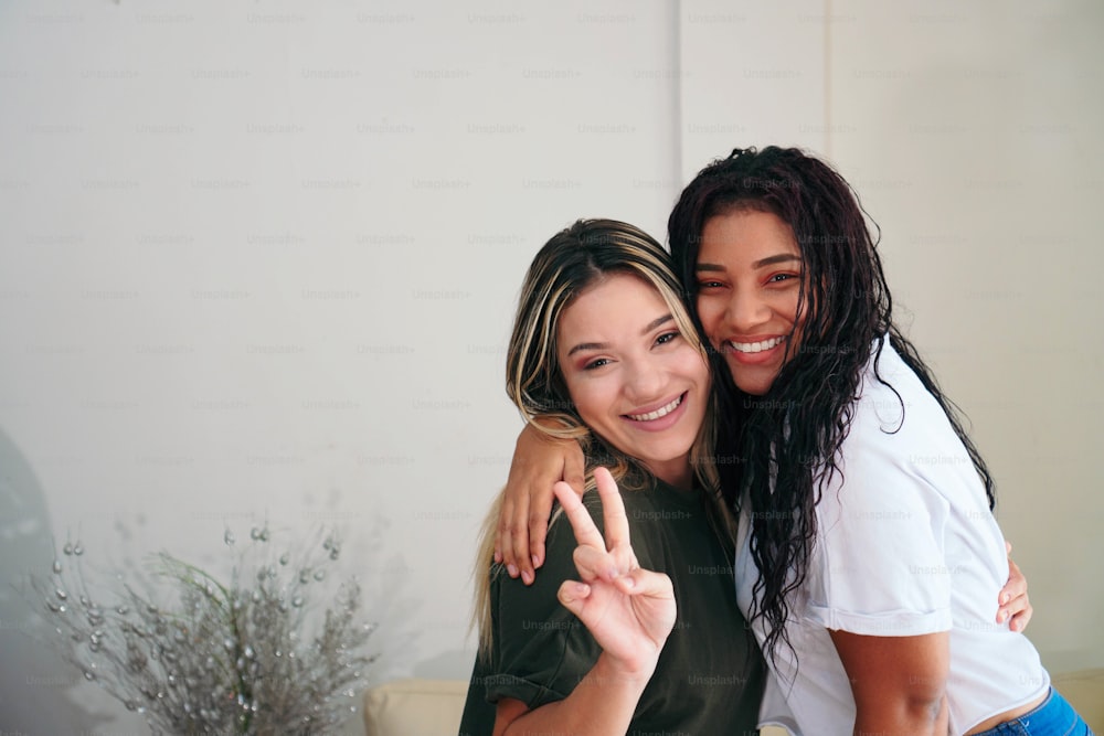 Portrait of two young beautiful smiling hipster females with summer. Friendly and carefree women posing at home. Positive models having fun, hugging and going crazy.