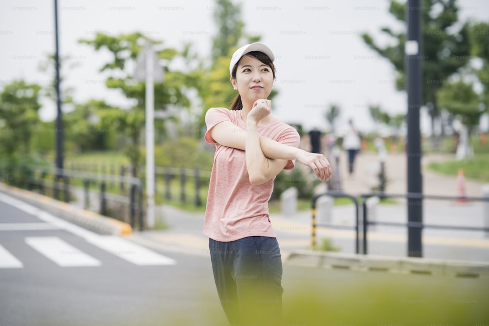 スポーツウェアを着て公園で運動するアジアの若い女性