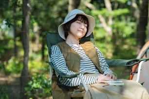 Solo camp image - A young woman taking a nap in front of a tent